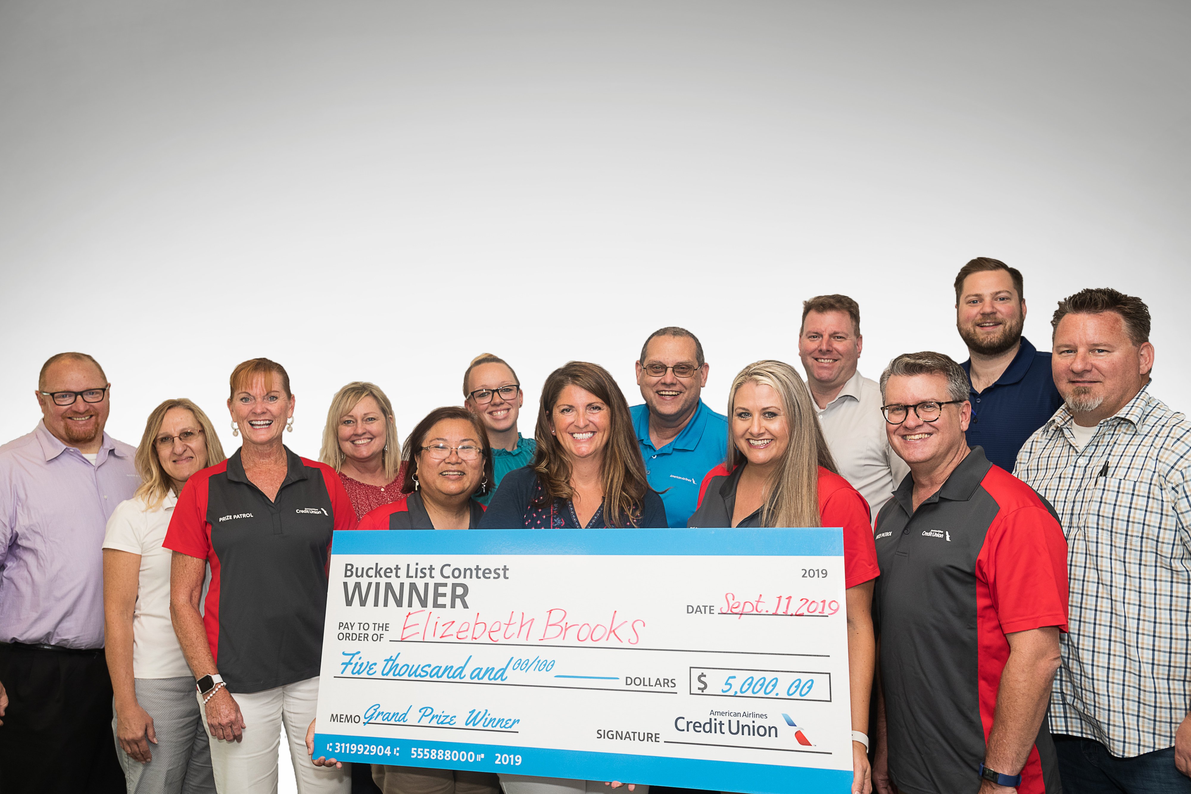 american airlines federal credit union employees holding big check with winner